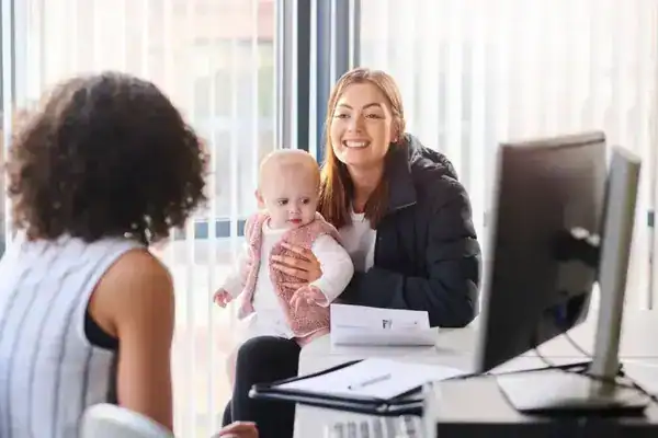 Our Values Woman with baby consulting lawyer in office setting.